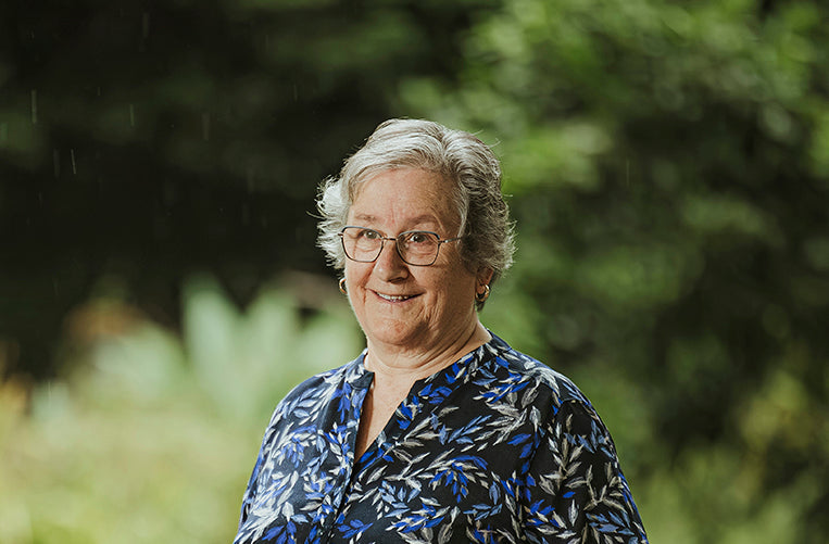 Jenny McGlone author of Jimmy Whiskers and the Great Parrot Rescue. Standing in her garden smiling.
